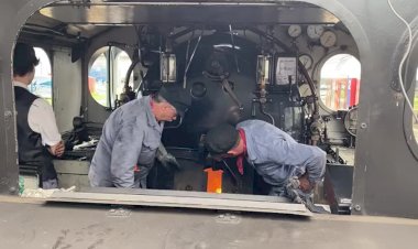 Кочегар кидает уголь в топку паровоза